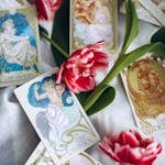 A striking arrangement of tarot cards and red tulips on a soft background, creating a mystical atmosphere.