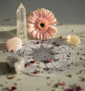 A harmonious setup of crystals and a flower around a pagan chart, symbolizing balance and spirituality.